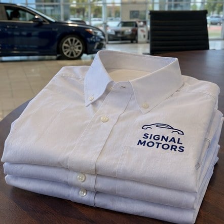Custom dealership dress shirts on a sales desk