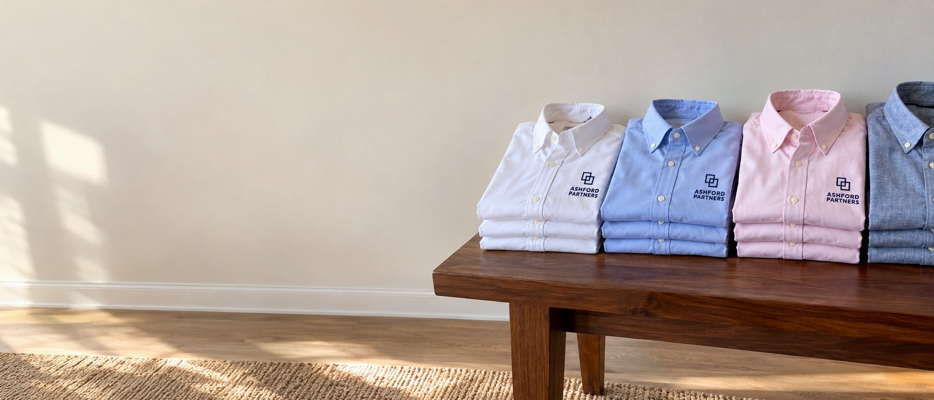 Custom embroidered dress shirts folded on a wooden table